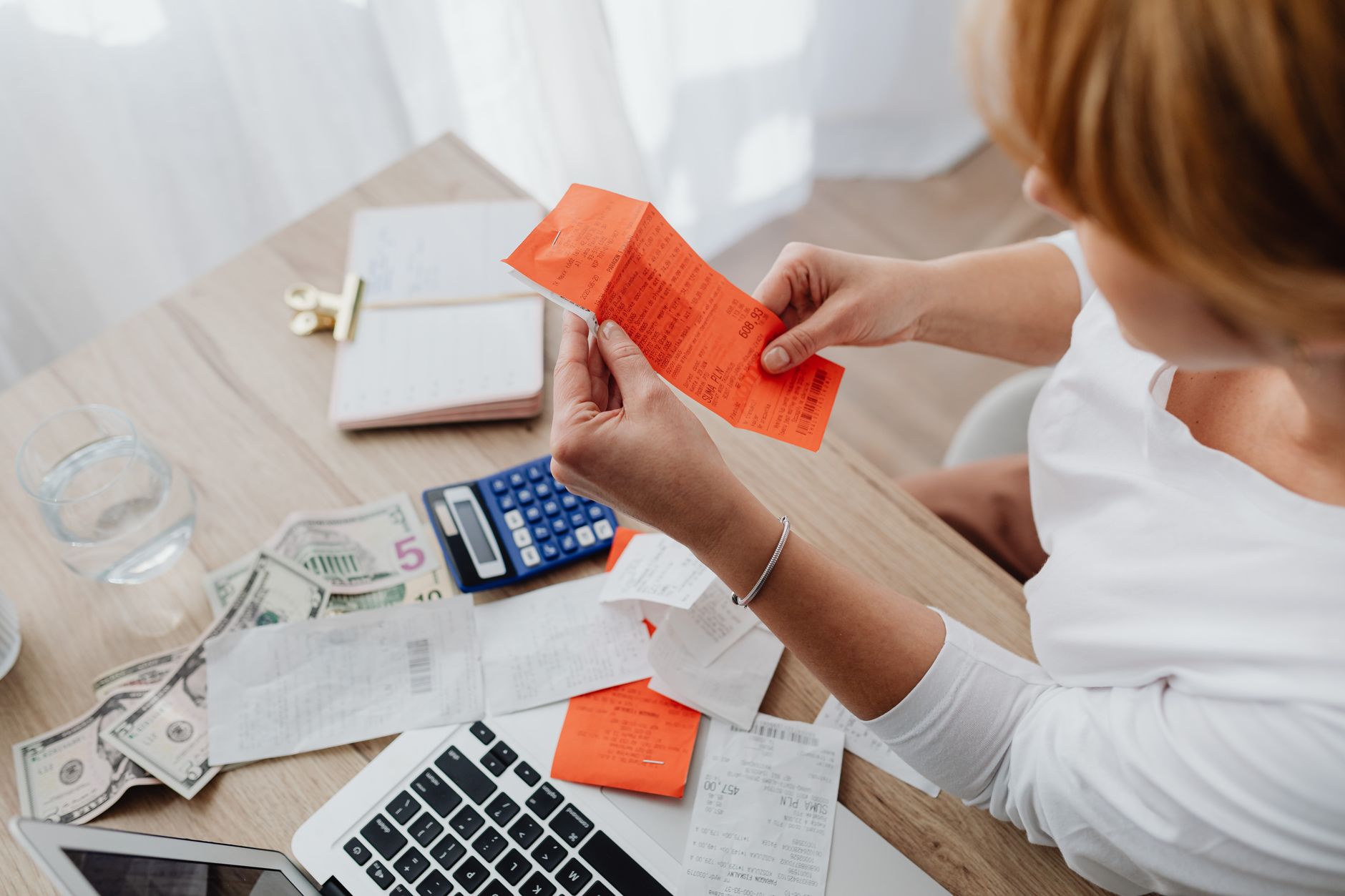 Person using a calculator with receipts to budget expenses